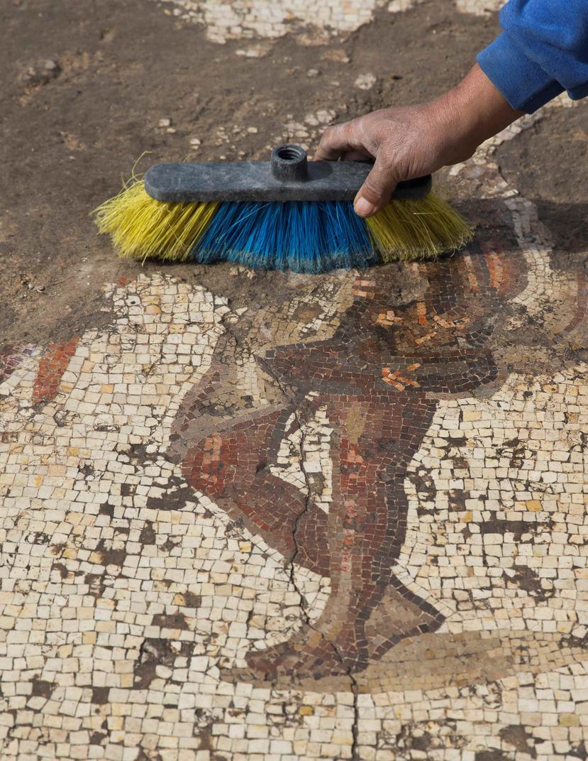 Un arqueólogo realiza labores de restauración en un mosaico del período romano recién recuperado en una excavación arqueológica en el parque nacional de la localidad de Cesarea, Israel (EFE / Atef Safadi).