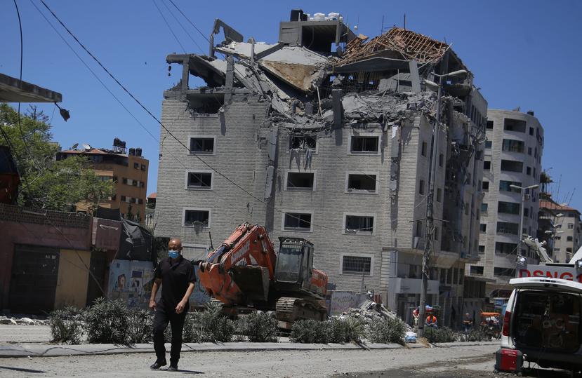 Un palestino camina por un edificio golpeado por un ataque aéreo israelí en la ciudad de Gaza, el martes 18 de mayo de 2021.