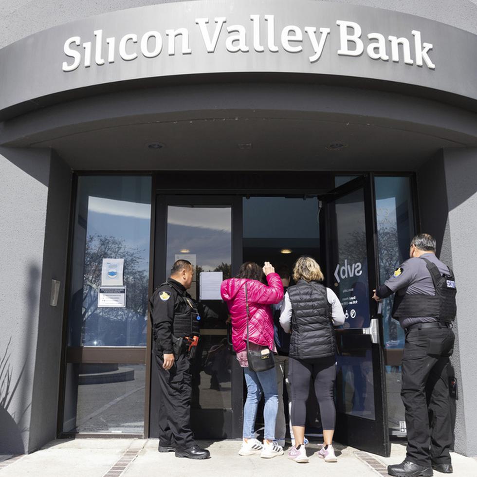 Guardias de seguridad permiten a personas ingresar en la sede del Silicon Valley Bank en Santa Clara, California, el lunes 13 de marzo de 2023. (AP Foto/ Benjamin Fanjoy)