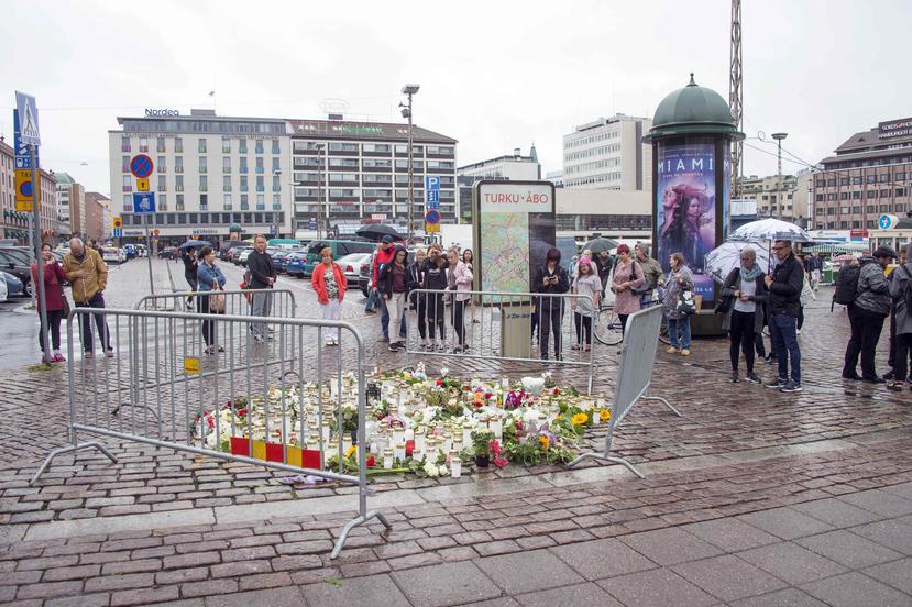 Las personas encienden velas y ponen flores en el lugar donde ocurrió el atentado de Turku. (EFE)