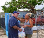 La repartición por la comunidad se dio casa a casa. En la foto, el presidente cameral Carlos Méndez entrega alimentos a una residente de Luquillo. (Suministrada)