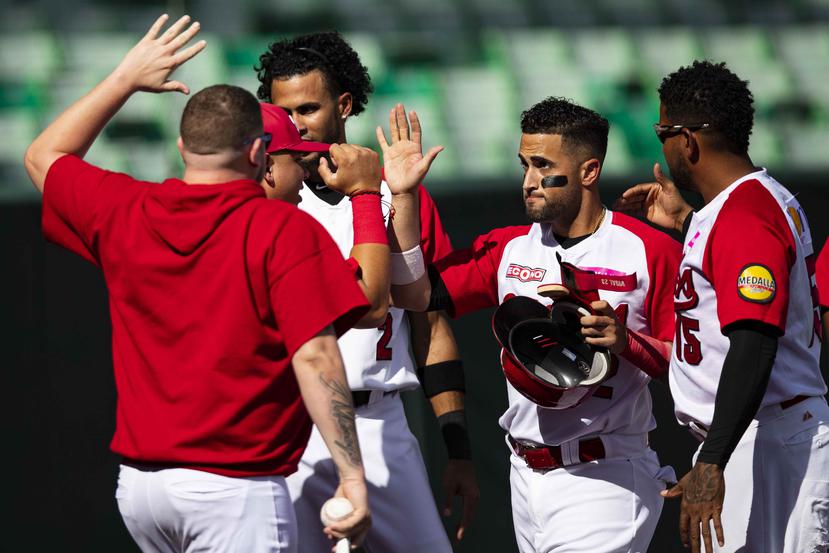 David Vidal (en primer plano) es felicitado por sus compañeros de equipo luego de anotar una carrera para los Criollos de Caguas.