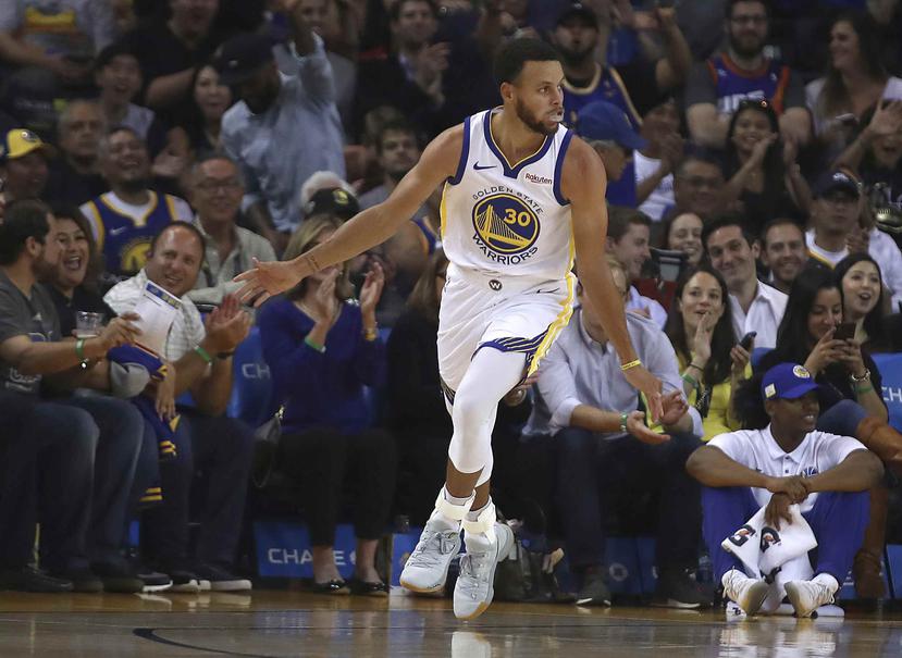 El astro de los Golden State Warriors Stephen Curry celebra tras anotar contra los Suns de Phoenix en un partido de pretemporada de la NBA. (AP)
