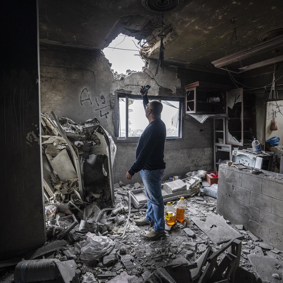 Hussein Fawaz revisa los daños en su casa que fue alcanzada por proyectiles israelíes en la localidad de Kfar Kila, cerca de la frontera de Líbano con Israel, el sábado 25 de noviembre de 2023.