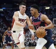 El alero de los 76ers, Tobias Harris (12), conduce hacia la canasta mientras el escolta del Heat, Tyler Herro (14), defiende, durante la primera mitad del primer juego de la serie de playoffs de segunda ronda la NBA.