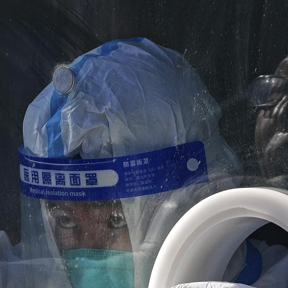 Un trabajador médico con equipo de protección recoge una muestra de un residente en un centro de pruebas de coronavirus en el distrito de Xichen en Beijing.