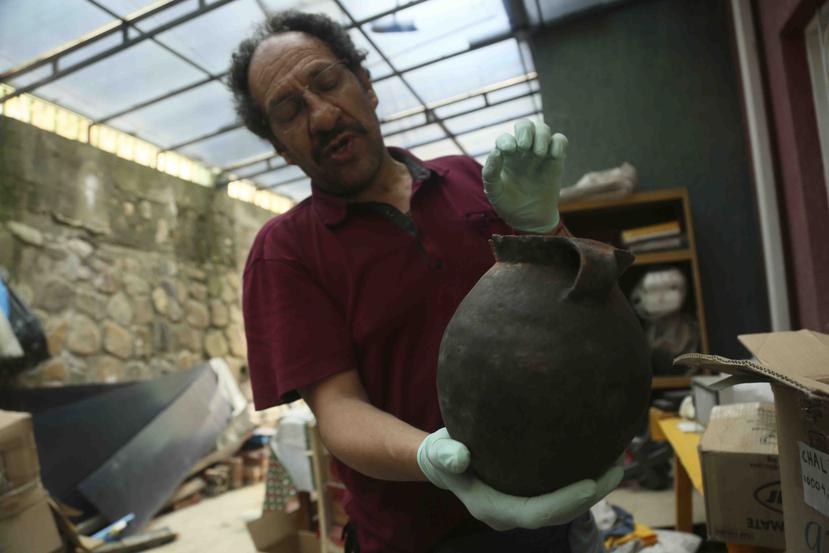 El arqueólogo Jedu Sadarnaga muestra una vasija descubierta en una de las tumbas halladas en un cementerio inca cerca de La Paz, Bolivia. (AP)