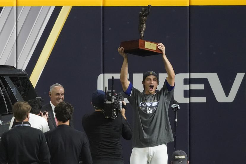 Corey Seager alza el trofeo de Jugador Más Valioso de la Serie Mundial entregado por el comisionado Rob Manfred.