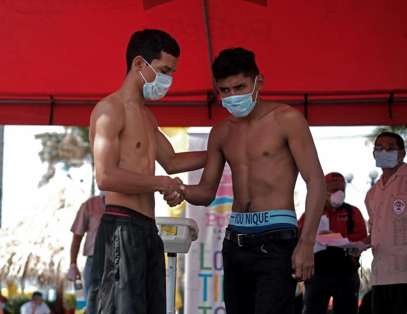 Dos jóvenes boxeadores se saludan el pasado viernes después de realizar un cara a cara durante el pesaje oficial para la velada boxí­stica con entrada gratuita en Managua. (Agencia EFE)