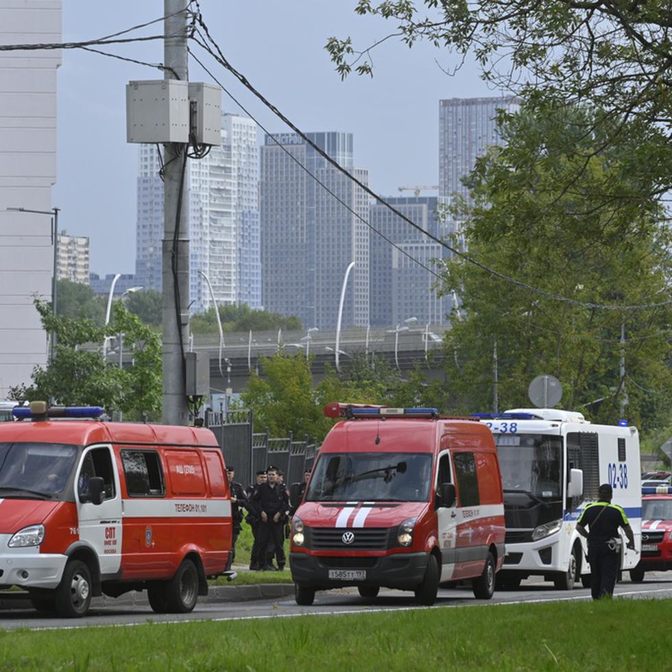 Vehículos policiales y de emergencias están estacionados al lado de los escombros de un dron caído cerca del terraplén Karamyshevskaya en Moscú, viernes 11 de agosto de 2023. (AP Foto)