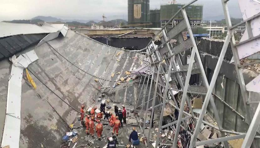 En esta imagen extraída de un video, rescatistas buscan sobrevivientes en el lugar donde se derrumbó un edificio en Baise City. (CCTV via AP)