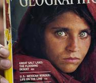 El paquistaní Inam Khan, dueño de una librería, muestra una copia de una revista de National Geographic con la fotografía de la refugiada afgana Sharbat Gulla, en Islamabad, Pakistán.