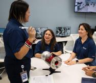 La profesora del RUM Sheilla Torres, al centro mientras conversa con dos estudiantes, estuvo en el proceso desde identificar el espacio hasta la inauguración del TurboLab auspiciado por la compañía de diseño y creación de motores para aeronaves Pratt & Whitney.