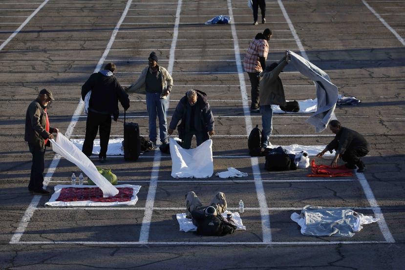 Pintan rectángulos en una playa de estacionamiento donde deben dormir los indigentes en Las Vegas, 30 de marzo de 2020. (AP)