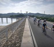 Un grupo de ciclistas pedalea junto al Embalse Miyun, en las afueras de Beijing, el 13 de julio del 2022. (AP Photo/Mark Schiefelbein)