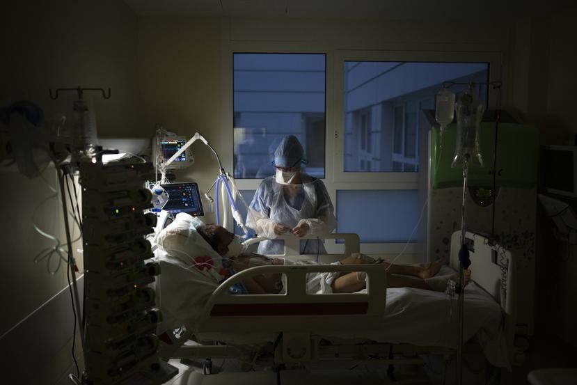 Una enfermera atiende a un enfermo con COVID-19 que recibe apoyo de un respirador en la Unidad de Cuidados Intensivos de un hospital.