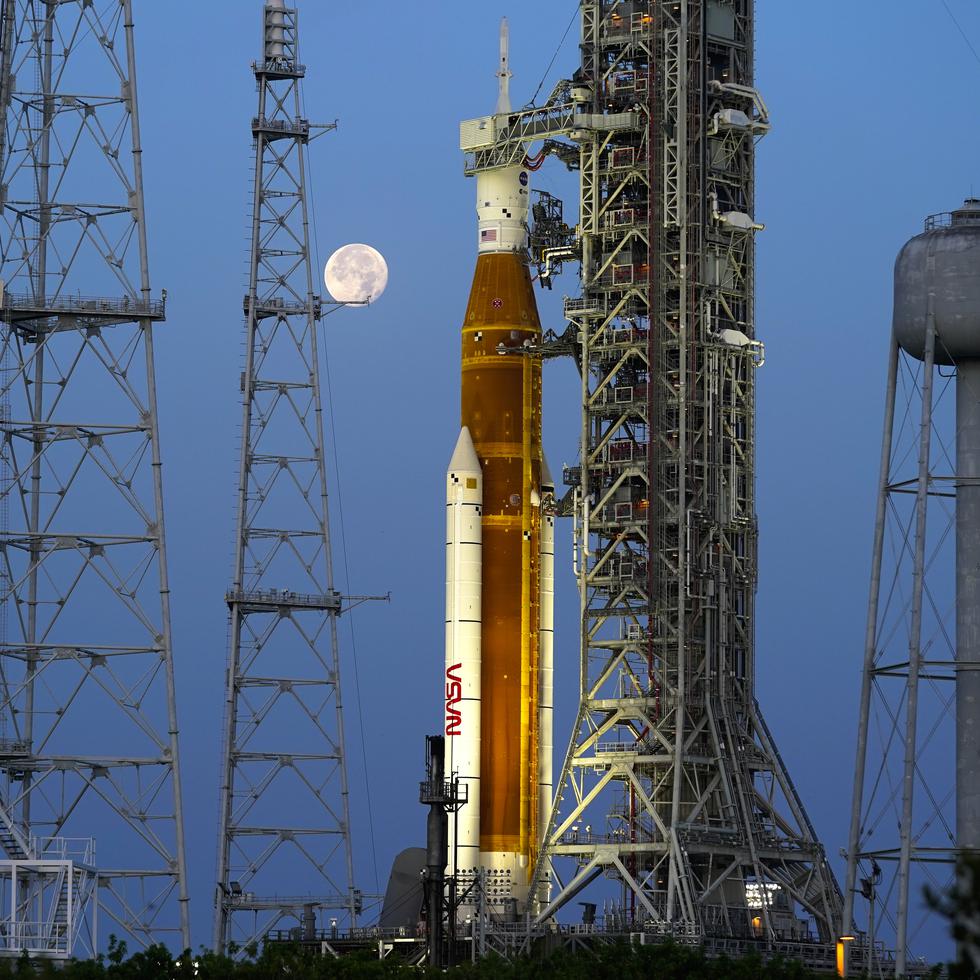 La luna se pone frente al cohete Artemis de la NASA con la nave espacial Orion a bordo en la plataforma 39B en el Centro Espacial Kennedy.