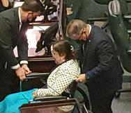 Wanda del Valle es sacada en silla de ruedas del hemiciclo. (nydia.bauza@gfrmedia.com)