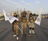 Combatientes del Talibán sostienen banderas del grupo en Kabul, Afganistán, el lunes 30 de agosto de 2021.