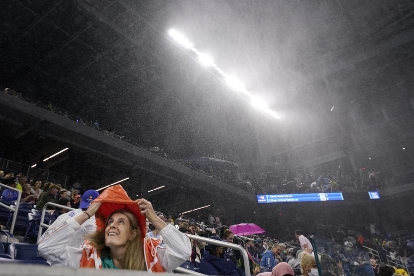 Una fanática se cubre de la lluvia en el estadio Louis Armstrong durante el partido entre Kevin Anderson y Diego Schwartzman en la segunda ronda del Abierto de Estados Unidos.