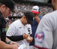 El artista puertorriqueño Daddy Yankee firma una pelota mientras entrega el lineup de los White Sox de Chicago el domingo.