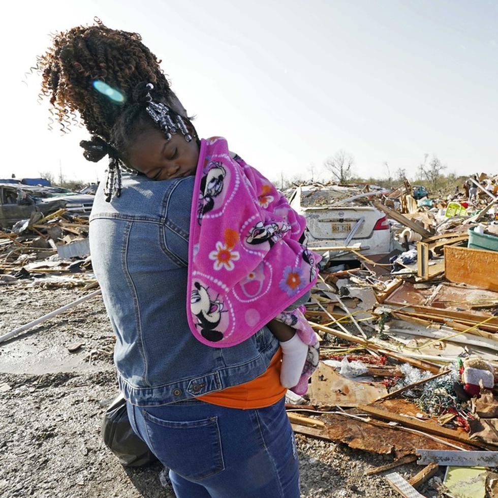 Wonder Bolden acuna a su nieta de un año, Journey Bolden, mientras observa los restos de la casa móvil de su madre demolida por el tornado en Rolling Fork, Mississippi.
