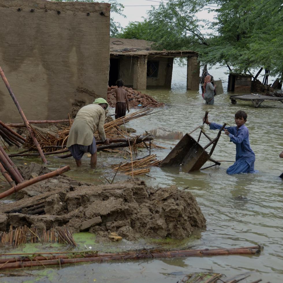 Una familia recupera artículos utilizables de su casa afectada por las inundaciones en Jaffarabad, un distrito de la provincia de Baluchistán, en el suroeste de Pakistán.