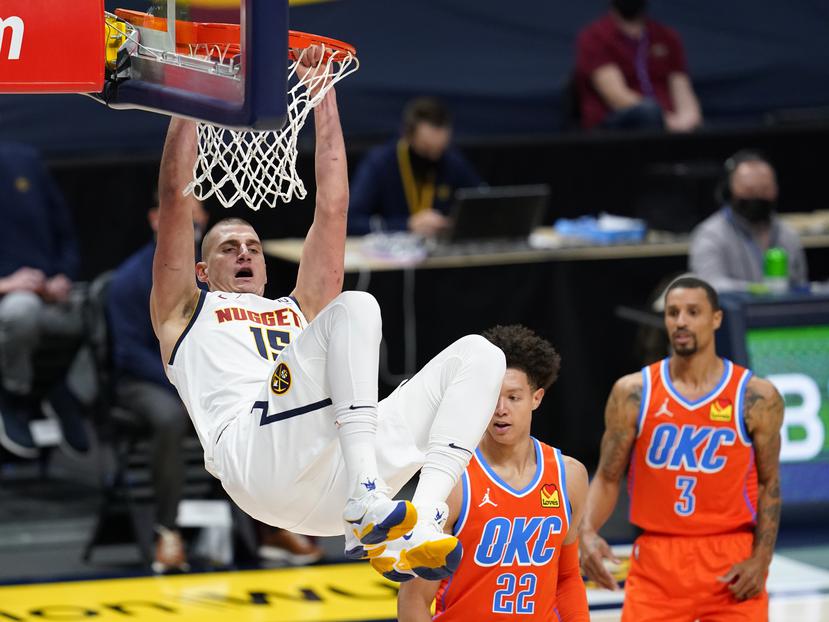 Nikola Jokic de los Nuggets de Denver se balancea en el aro tras encestar frente al Thunder de Oklahoma City el martes 19 de enero del 2021.