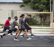 Varios de los jóvenes y la entrenadora Keren Canales se ejercitan durante uno de los entrenamientos en la cancha de balonmano de Naguabo.