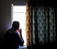 1714622476 - Elderly man indoors in the house looks out the window. Loneliness. Corona virus. Stay at home, stay safe. (Shutterstock)SOLITUDE, LONELINESS, SOLEDAD, AISLAMIENTO, ENVEJECIENTE, ADULTO MAYOR 