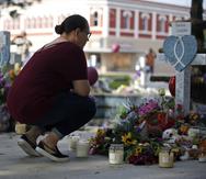 A woman pays her respects at a memorial site for the victims killed in this week's shooting at Robb Elementary School in Uvalde, Texas, Friday, May 27, 2022. (AP Photo/Dario Lopez-Mills)