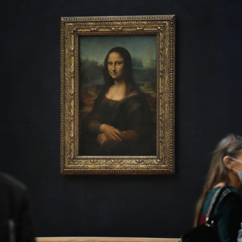 Periodistas pasan frente a la Mona Lisa de Leonardo da Vinci en el museo del Louvre, París.