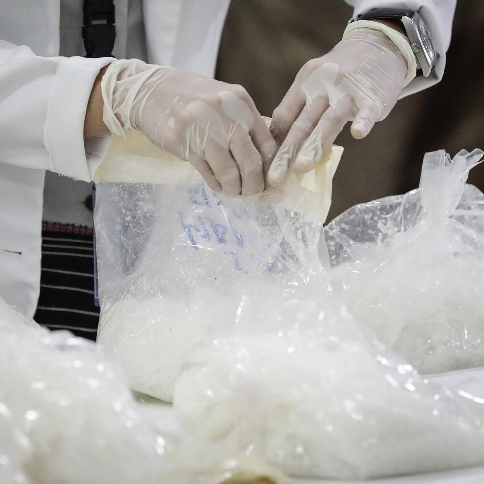 Un técnico forense inspecciona una bolsa del cargamento de 5,528 libras de metanfetamina ocupado en California.