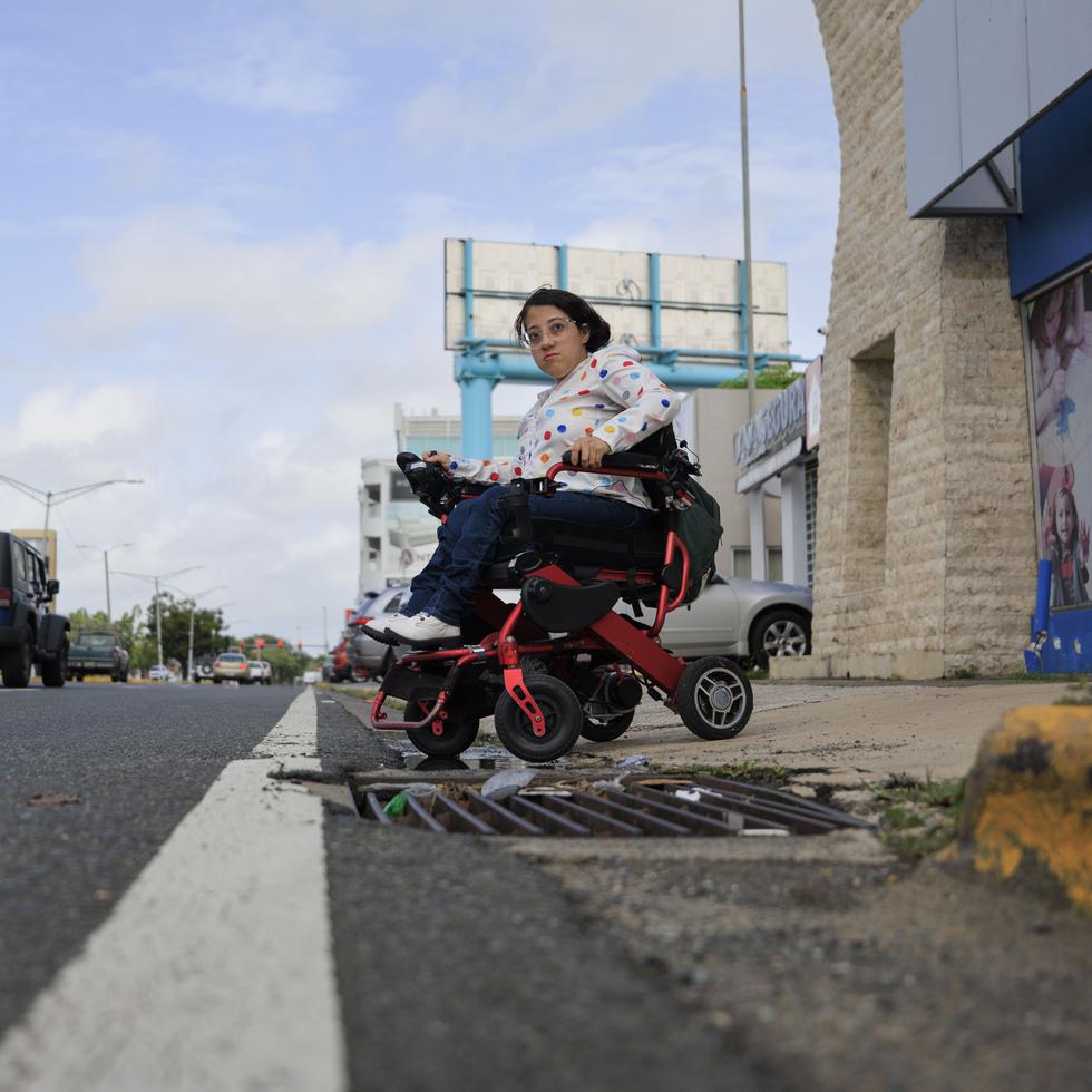 Stephanie Vázquez Pagán, una usuaria de silla de ruedas, se muestra preocupada cuando no le queda otra opción que pasar por una avenida junto al tráfico vehicular porque la acera estaba bloqueada, lo cual es peligroso.