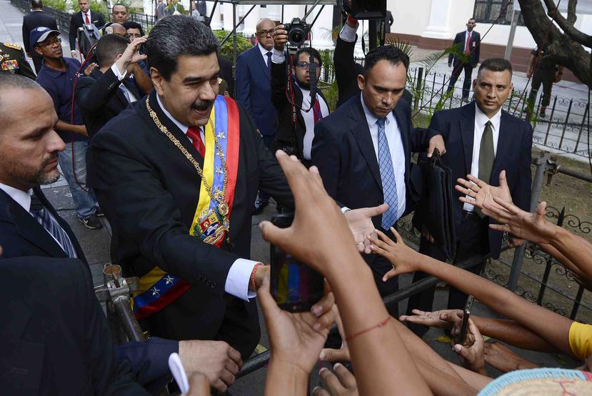 El presidente venezolano Nicolás Maduro, a la izquierda, saluda a sus partidarios. (AP/Matías Delacroix)