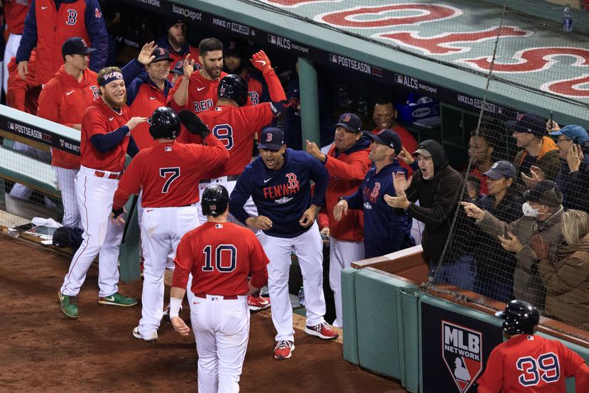 El dirigente de los Red Sox, Alex Cora, recibe a sus jugadores en el dugout luego de gran slam de Kyle Schwarber en la segunda entrada.