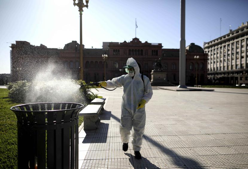 Un hombre desinfecta un pote de basura en la Plaza de Mayo de Buenos Aires, Argentina. (AP)
