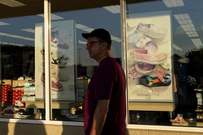 Un consumidor pasa por al frente de una tienda de zapatos.