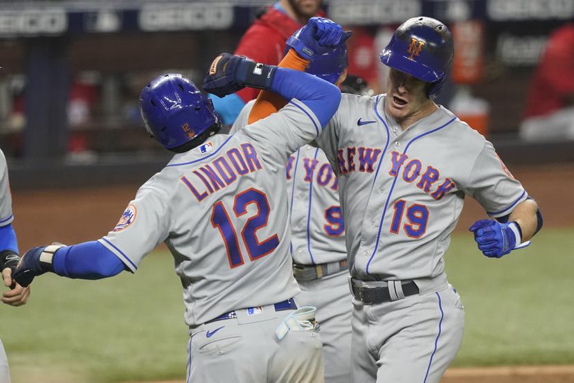 El puertorriqueño Francisco Lindor felicita a Mark Canha, quien conectó un 'grand slam' por los Mets de Nueva York el sábado ante los Marlins de Miami.