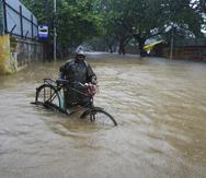 Un hombre empuja su bicicleta por una calle inundada en Chennai, en el estado sureño indio de Tamil Nadu.