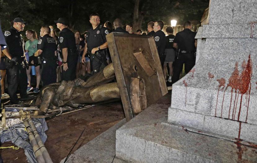 La Policía custodia la estatua derribada. (AP)