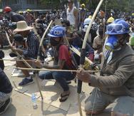 Manifestantes con arcos y flechas de fabricación casera se preparan para hacer frente a la policía durante una protesta en Birmania.