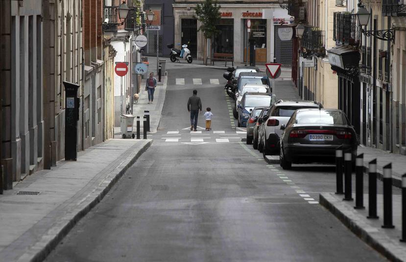 Un hombre camina con un niño por una de las principales calles de Madrid. (AP)