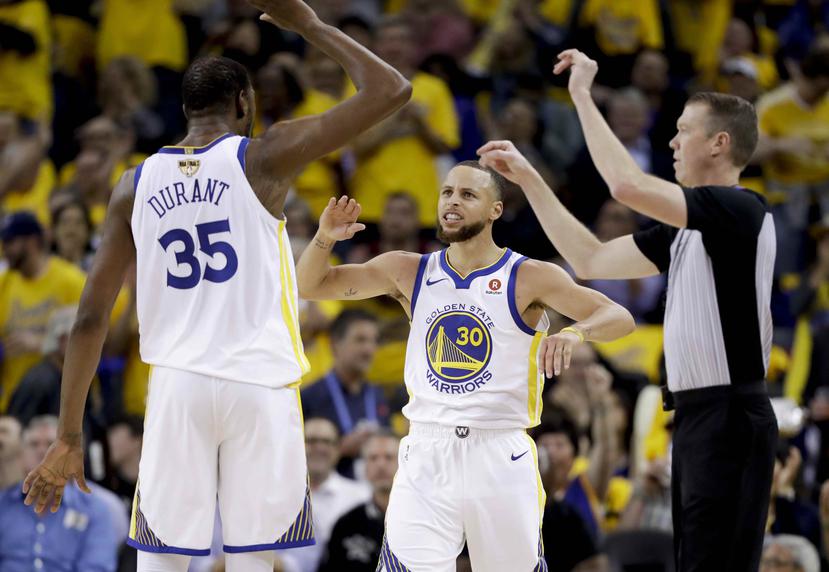 Kevin Durant y Stephen Curry, de los Warriors de Golden State, celebran una canasta. (AP)