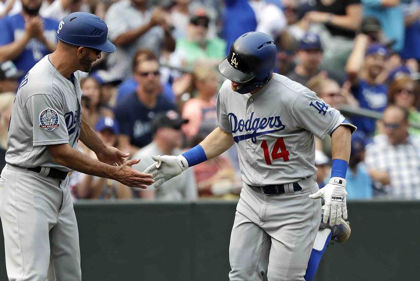 El coach de tercera base de los Dodgers Chris Woodward saluda a Kike Hernández, que se dirige al plato tras su vuelacercas solitario. (AP)