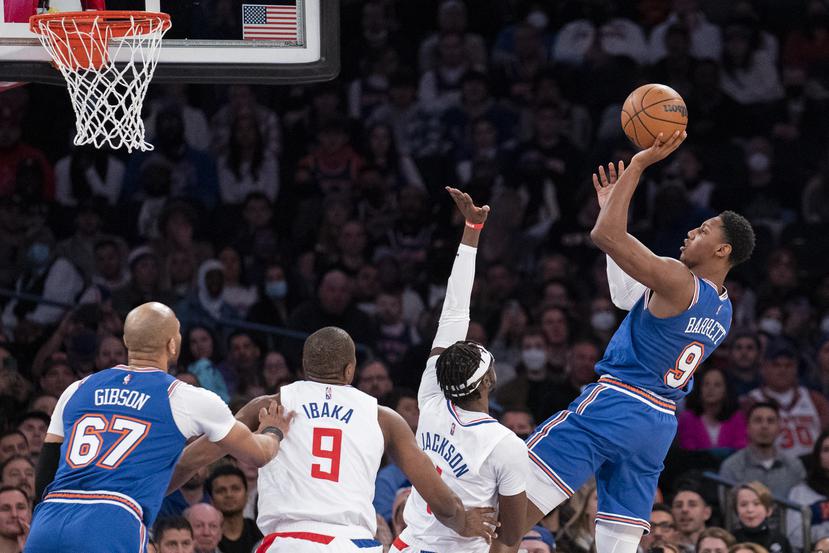 El base de los Knicks de Nueva York RJ Barrett lanza el balón sobre el base de los Clippers de Los Ángeles Reggie Jackson.