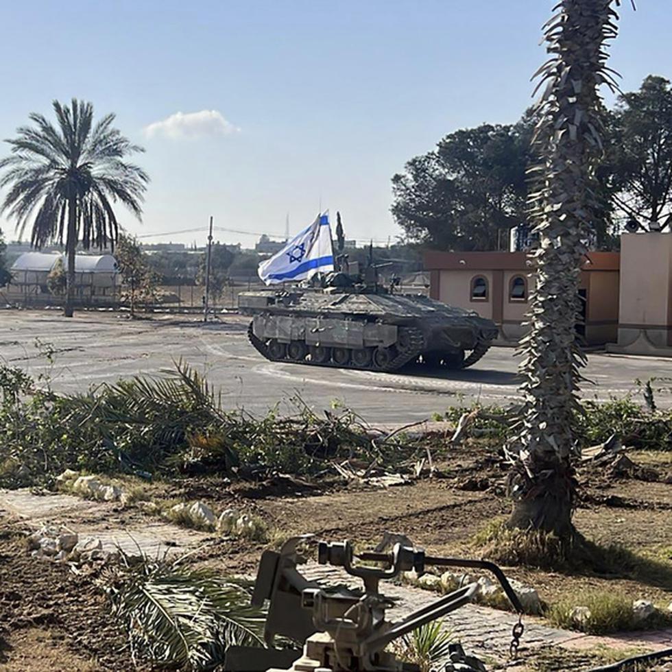 En esta imagen, del ejército de Israel, un tanque con una bandera israelí entra al lado gazatí del paso fronterizo de Rafah.
