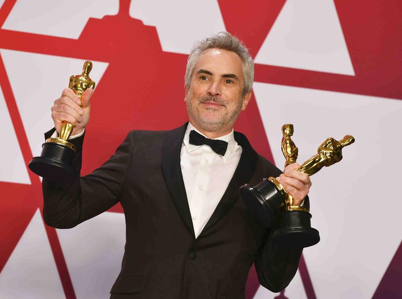 El director mexicano Alfonso Cuarón muestra las tres estatuillas que capturó en la noche del domingo. (AP / Jordan Strauss)