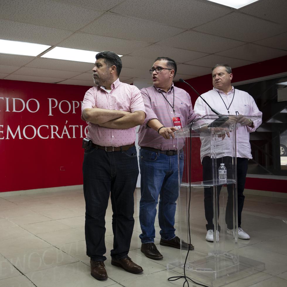 Desde la izquierda, el secretario general del PPD, Luis Vega Ramos; el comisionado electoral, Ramón Torres; y el comisionado electoral alterno, Jorge Colberg Toro, observan los votos en la pantalla en la sede del partido.