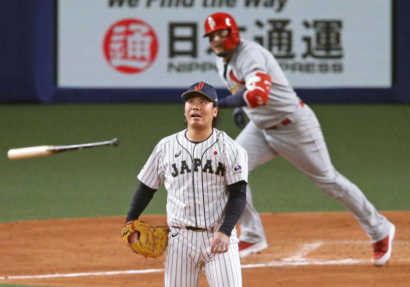 El lanzador japonés Haruhiro Hamaguch observa un doble conectado por Yadier Molina. (AP)
